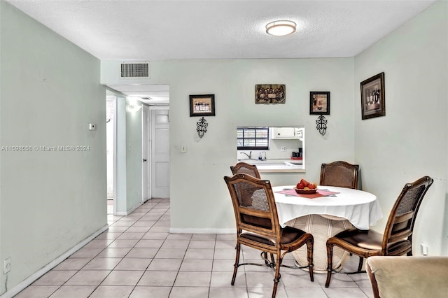 dining space with light tile patterned flooring and a textured ceiling