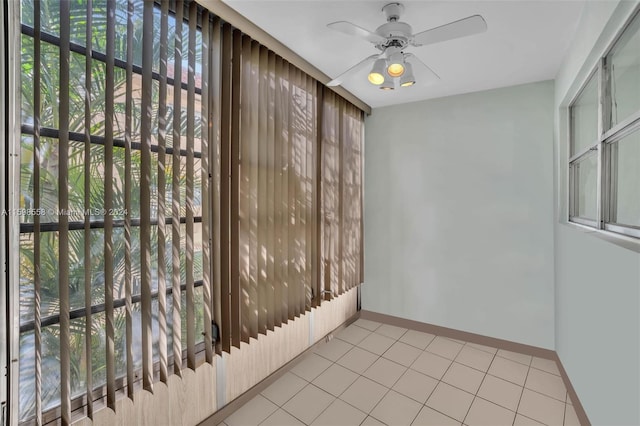 spare room with ceiling fan and light tile patterned flooring