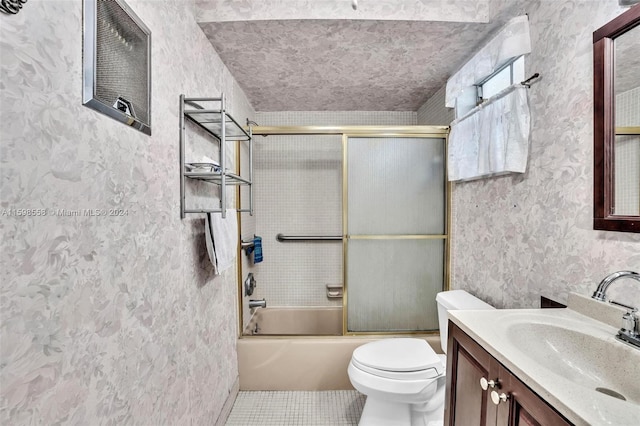 full bathroom with tile patterned flooring, vanity, combined bath / shower with glass door, and toilet