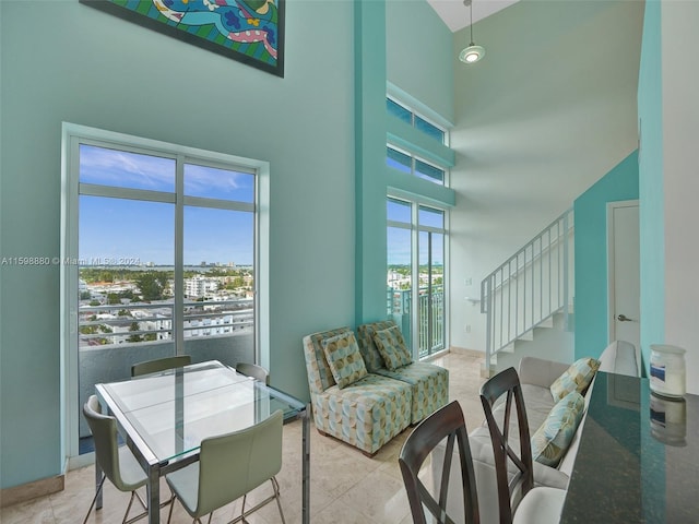 tiled dining room with a high ceiling and a healthy amount of sunlight