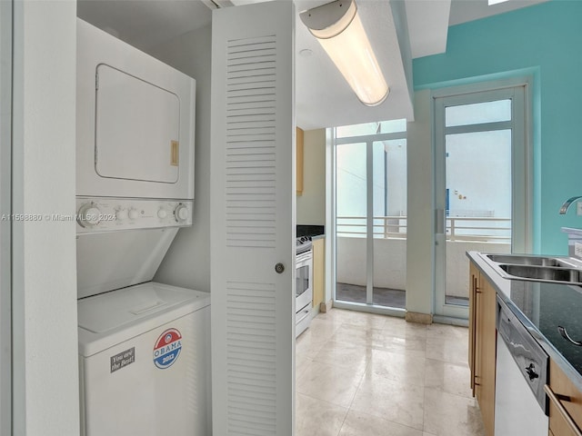 washroom featuring sink, light tile patterned flooring, and stacked washing maching and dryer