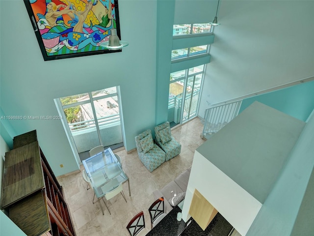 living room featuring a towering ceiling and tile patterned floors