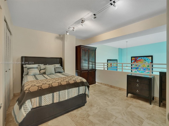 bedroom with track lighting and a textured ceiling