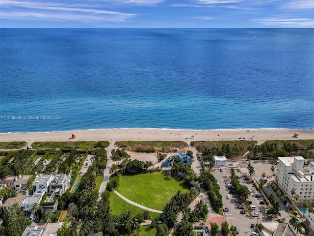 birds eye view of property with a water view and a beach view