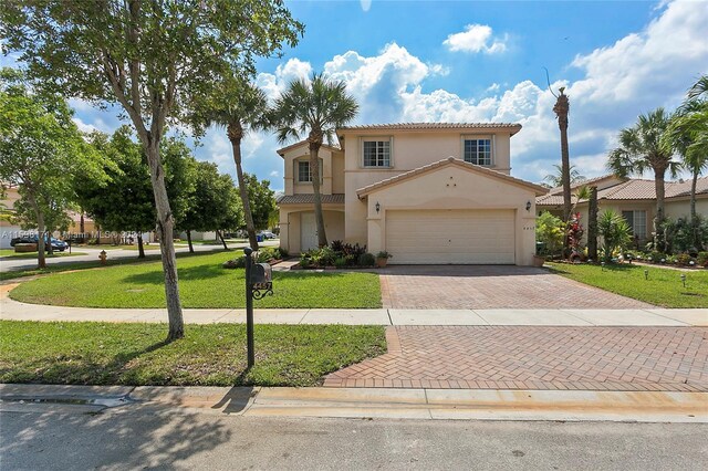 mediterranean / spanish house featuring a garage and a front yard