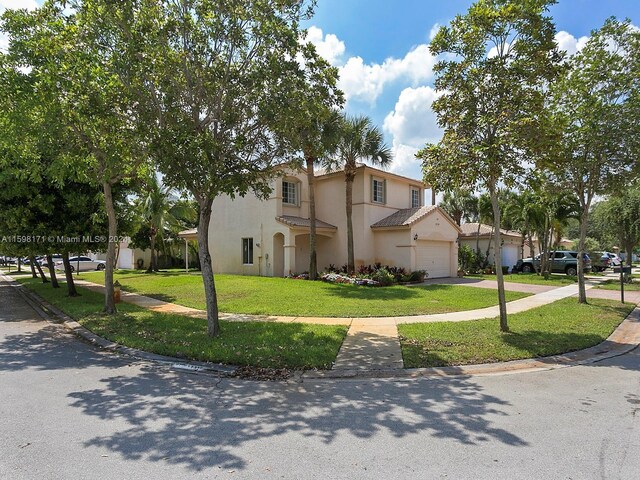 mediterranean / spanish home with a front yard and a garage