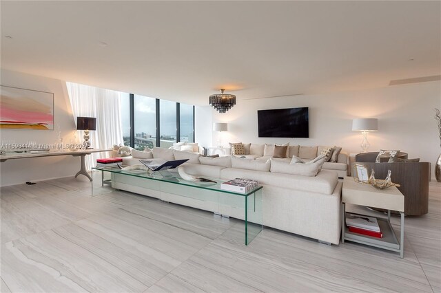 living room with an inviting chandelier and a wall of windows