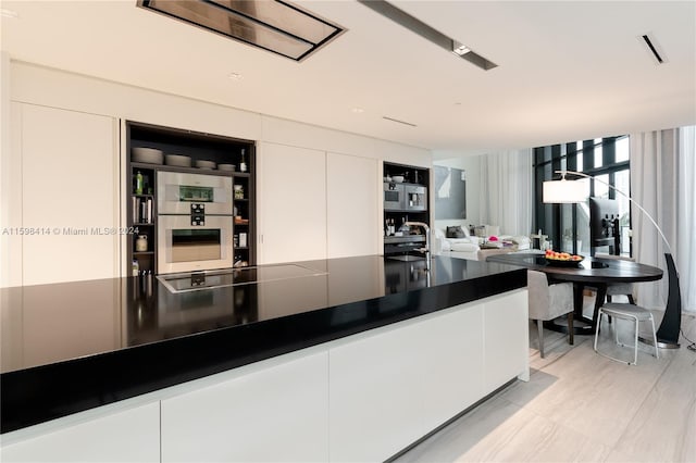 kitchen featuring stovetop, white cabinets, and sink