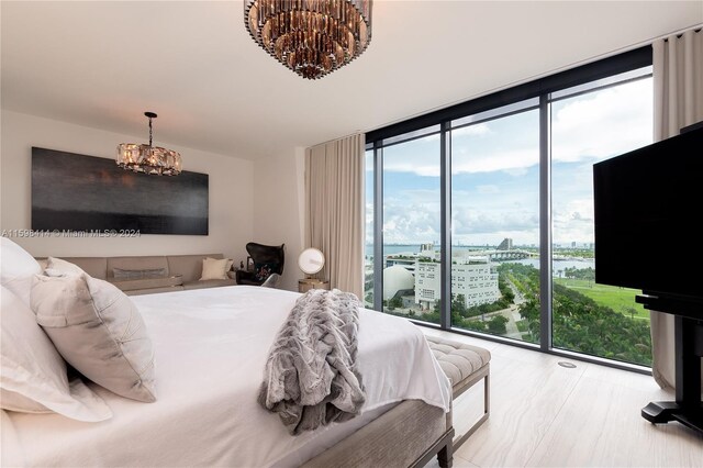 bedroom featuring a notable chandelier, floor to ceiling windows, and access to outside