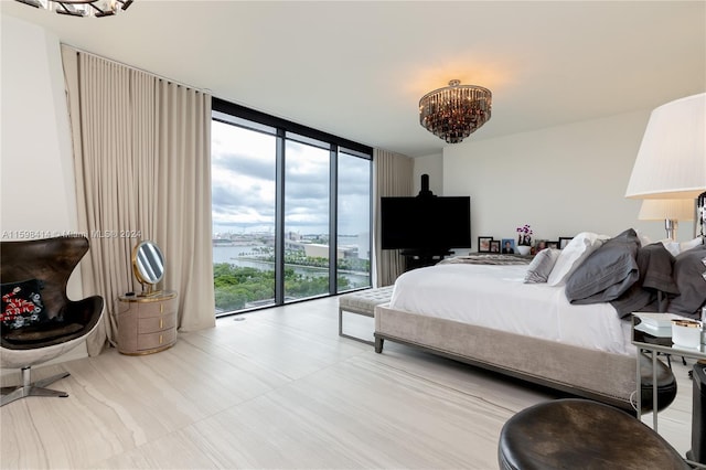 bedroom featuring a chandelier, access to exterior, and floor to ceiling windows