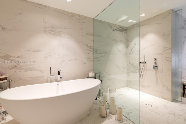 bathroom featuring plus walk in shower and tile walls