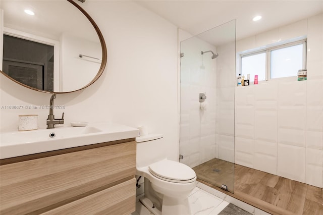 bathroom with vanity, a shower with shower door, and toilet