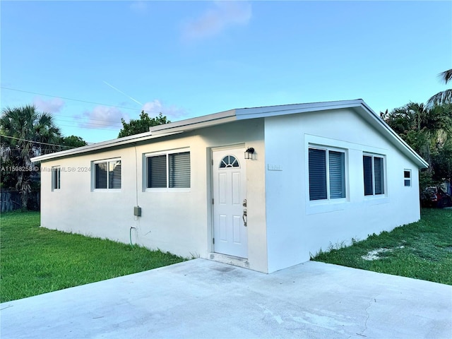 view of front of home with a patio and a front yard