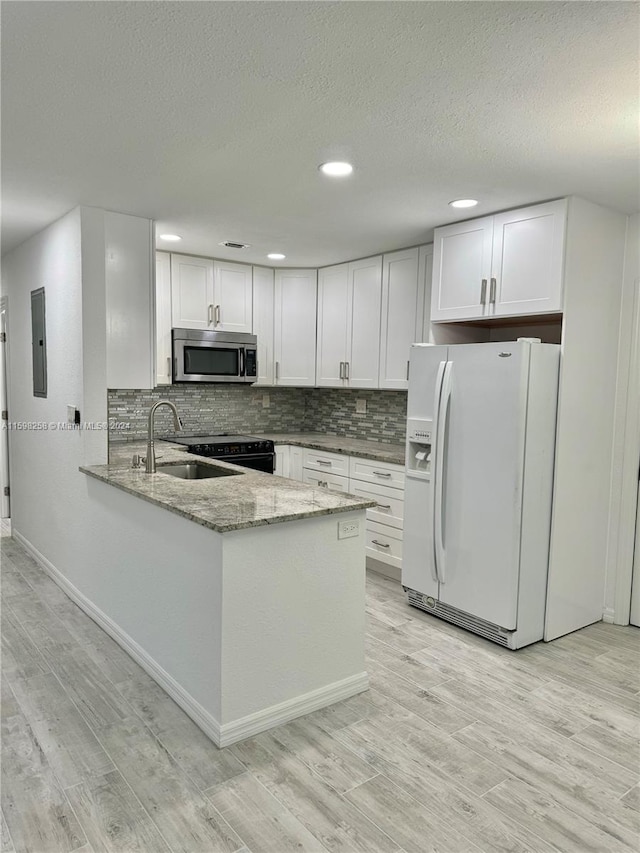 kitchen with white cabinetry, white fridge with ice dispenser, light hardwood / wood-style flooring, and light stone counters