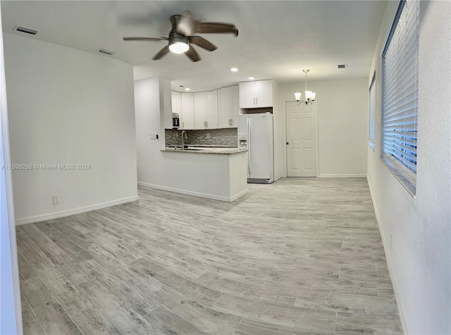 kitchen featuring white cabinetry, light wood-type flooring, backsplash, and white refrigerator with ice dispenser