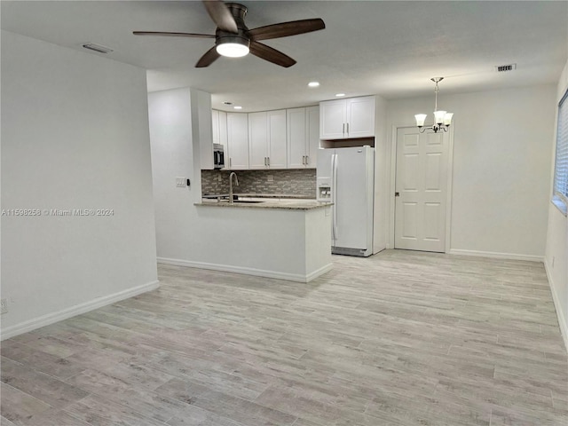 kitchen featuring white cabinetry, light hardwood / wood-style floors, white fridge with ice dispenser, and kitchen peninsula