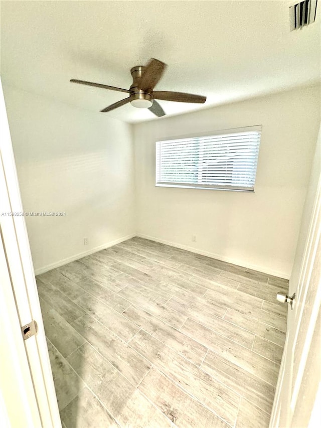 spare room featuring light hardwood / wood-style flooring and ceiling fan