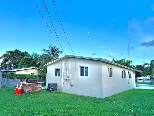 view of home's exterior featuring central air condition unit and a yard