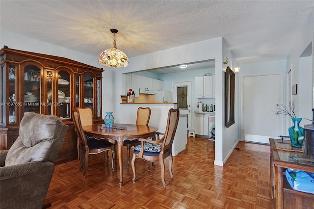 dining room with light parquet flooring, a textured ceiling, and a chandelier