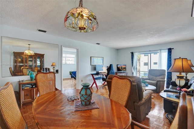 dining area with parquet flooring and a textured ceiling