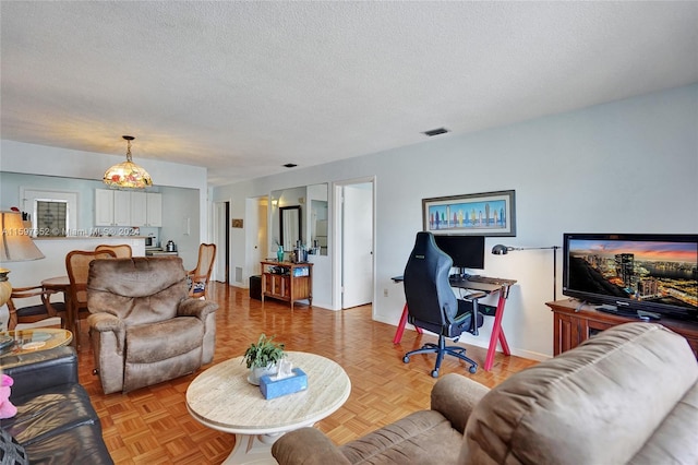 living room with light parquet floors and a textured ceiling