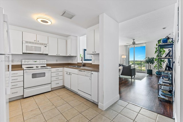 kitchen featuring light wood-type flooring, white appliances, ceiling fan, sink, and white cabinets