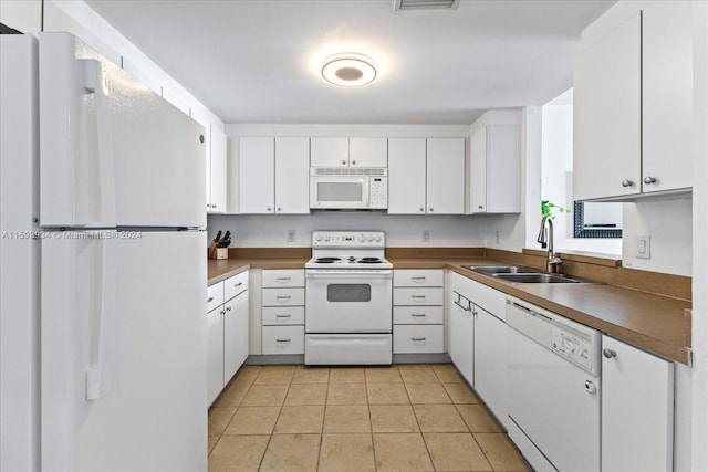 kitchen with white cabinets, light tile patterned floors, white appliances, and sink