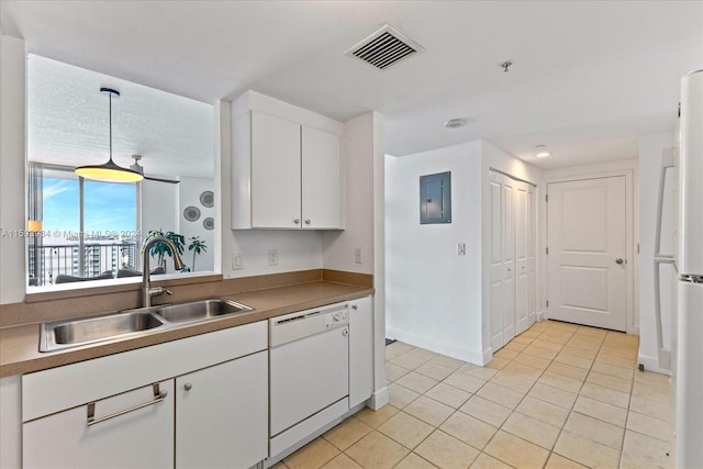 kitchen with white appliances, sink, light tile patterned floors, decorative light fixtures, and white cabinets