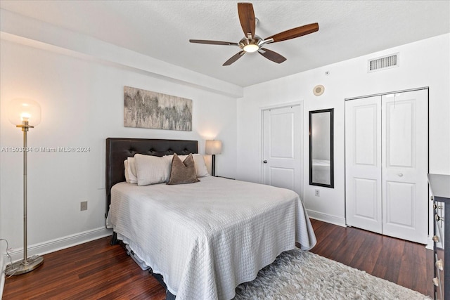 bedroom featuring a textured ceiling, a closet, ceiling fan, and dark wood-type flooring