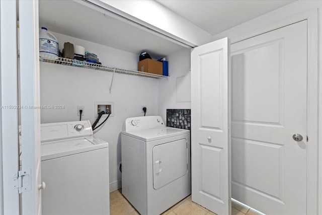 clothes washing area featuring light tile patterned floors and washer and dryer