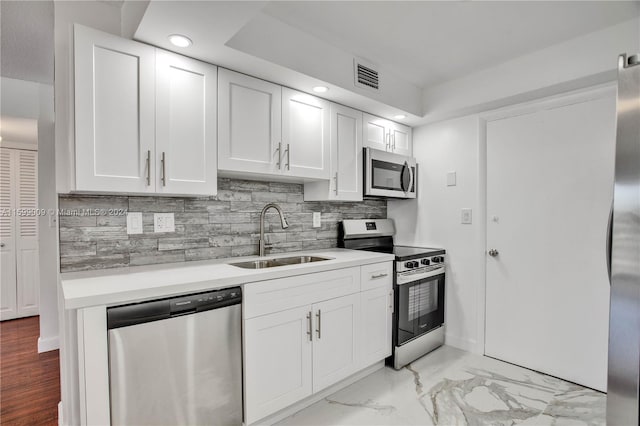 kitchen featuring backsplash, stainless steel appliances, white cabinetry, and sink