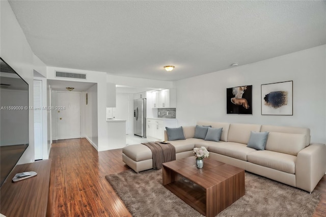 living room featuring wood-type flooring and a textured ceiling