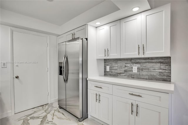 kitchen featuring white cabinets, stainless steel fridge with ice dispenser, and backsplash