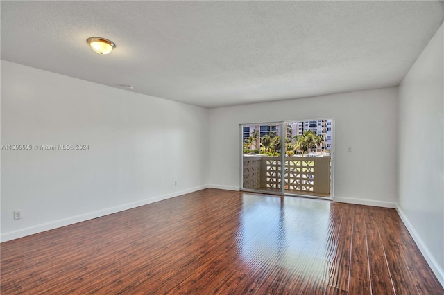 spare room with hardwood / wood-style floors and a textured ceiling