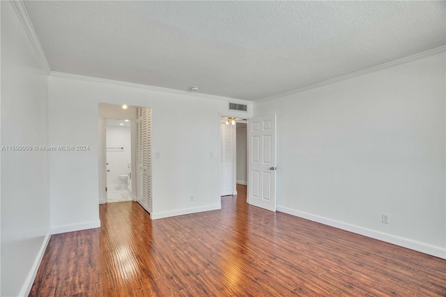 empty room featuring a textured ceiling, dark hardwood / wood-style flooring, ceiling fan, and ornamental molding