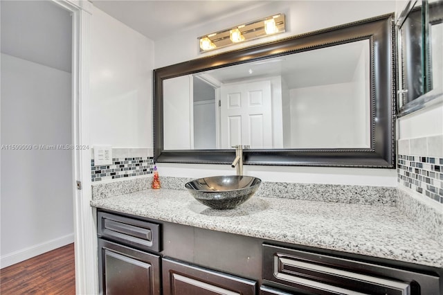 bathroom with backsplash, hardwood / wood-style floors, and vanity