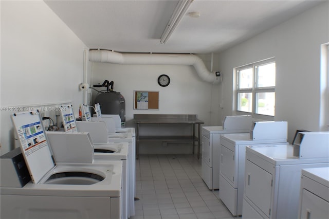 washroom featuring light tile patterned floors, washing machine and dryer, and electric water heater