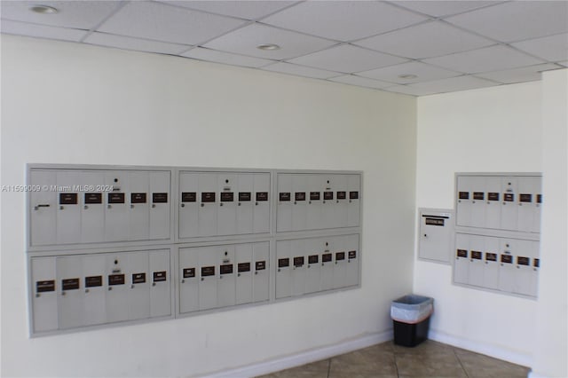 interior details featuring mail boxes and a drop ceiling