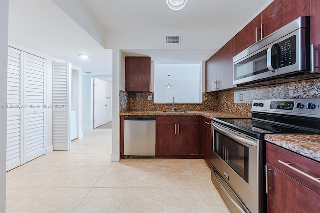 kitchen featuring stone counters, sink, appliances with stainless steel finishes, tasteful backsplash, and light tile patterned flooring