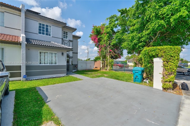 back of property with a patio and a lawn