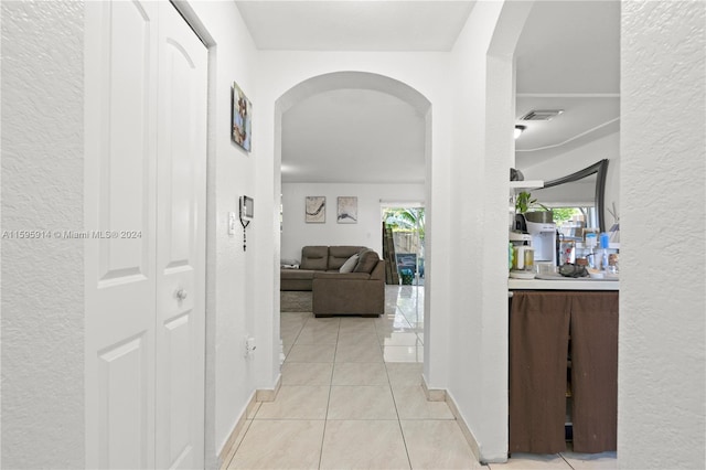 corridor with a wealth of natural light and light tile patterned floors