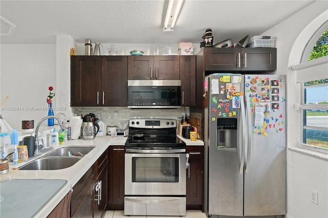 kitchen with tasteful backsplash, dark brown cabinetry, appliances with stainless steel finishes, and sink