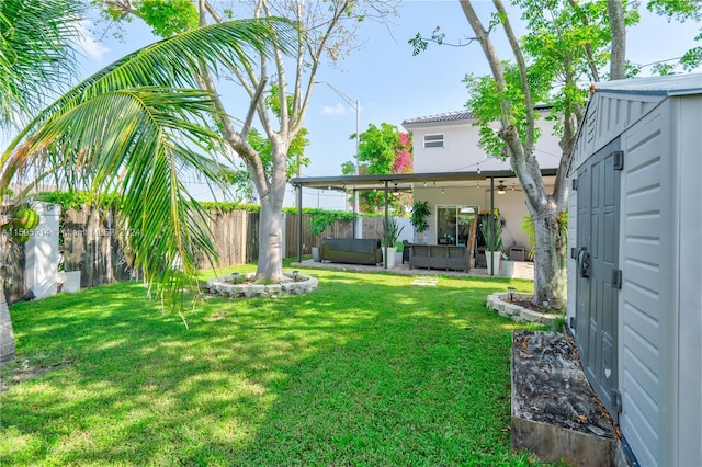 view of yard featuring a hot tub, a patio, outdoor lounge area, and a shed