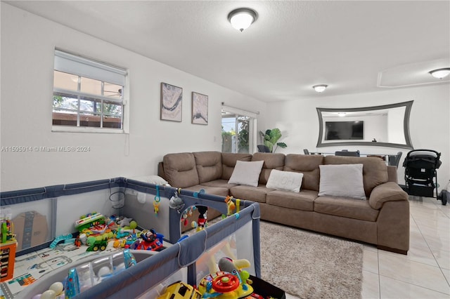 living room featuring a textured ceiling and light tile patterned floors