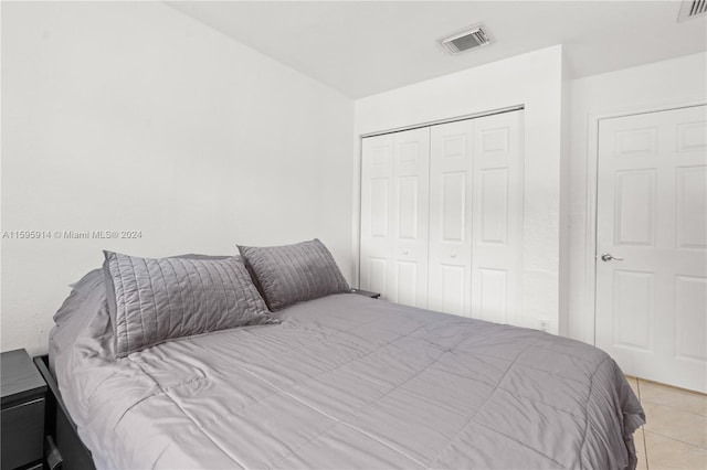 bedroom with light tile patterned floors and a closet