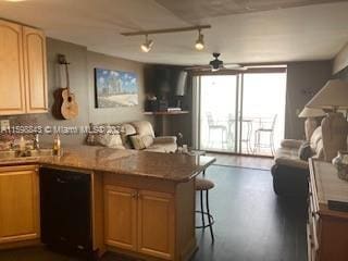 kitchen featuring a kitchen breakfast bar, a wall of windows, kitchen peninsula, ceiling fan, and black dishwasher