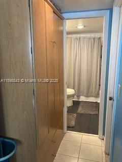 bathroom featuring tile patterned floors, toilet, and a shower with curtain