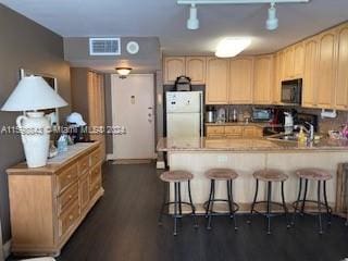 kitchen featuring kitchen peninsula, dark hardwood / wood-style floors, white fridge, light brown cabinetry, and sink