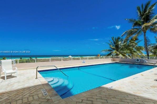 view of swimming pool with a patio and a water view