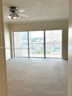 carpeted spare room with ceiling fan